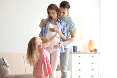 Photo of Young pregnant woman with her family at home