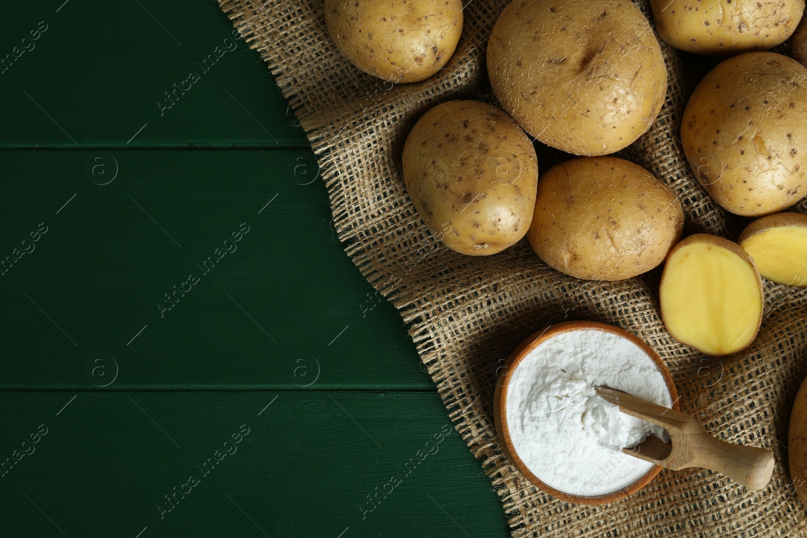 Photo of Starch and fresh raw potatoes on green wooden table, flat lay. Space for text