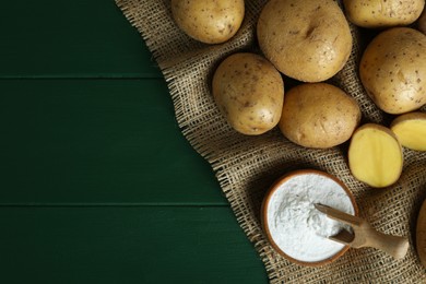 Starch and fresh raw potatoes on green wooden table, flat lay. Space for text