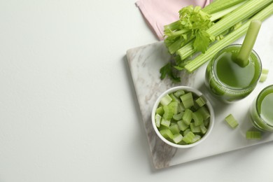 Photo of Glasses of delicious celery juice and vegetables on white table, flat lay. Space for text