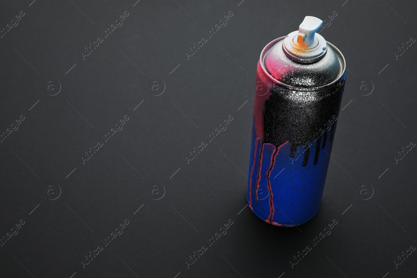 Photo of Used can of spray paint on black background, space for text. Graffiti supply