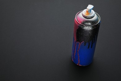 Photo of Used canspray paint on black background, space for text. Graffiti supply