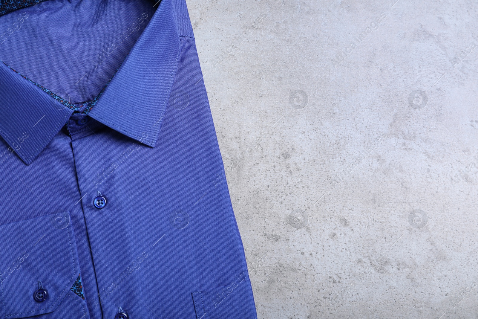 Photo of Stylish blue shirt on grey background, top view with space for text. Dry-cleaning service