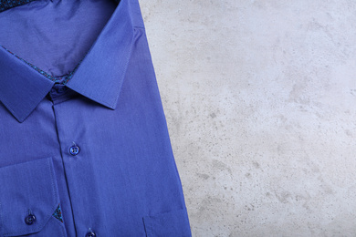 Photo of Stylish blue shirt on grey background, top view with space for text. Dry-cleaning service