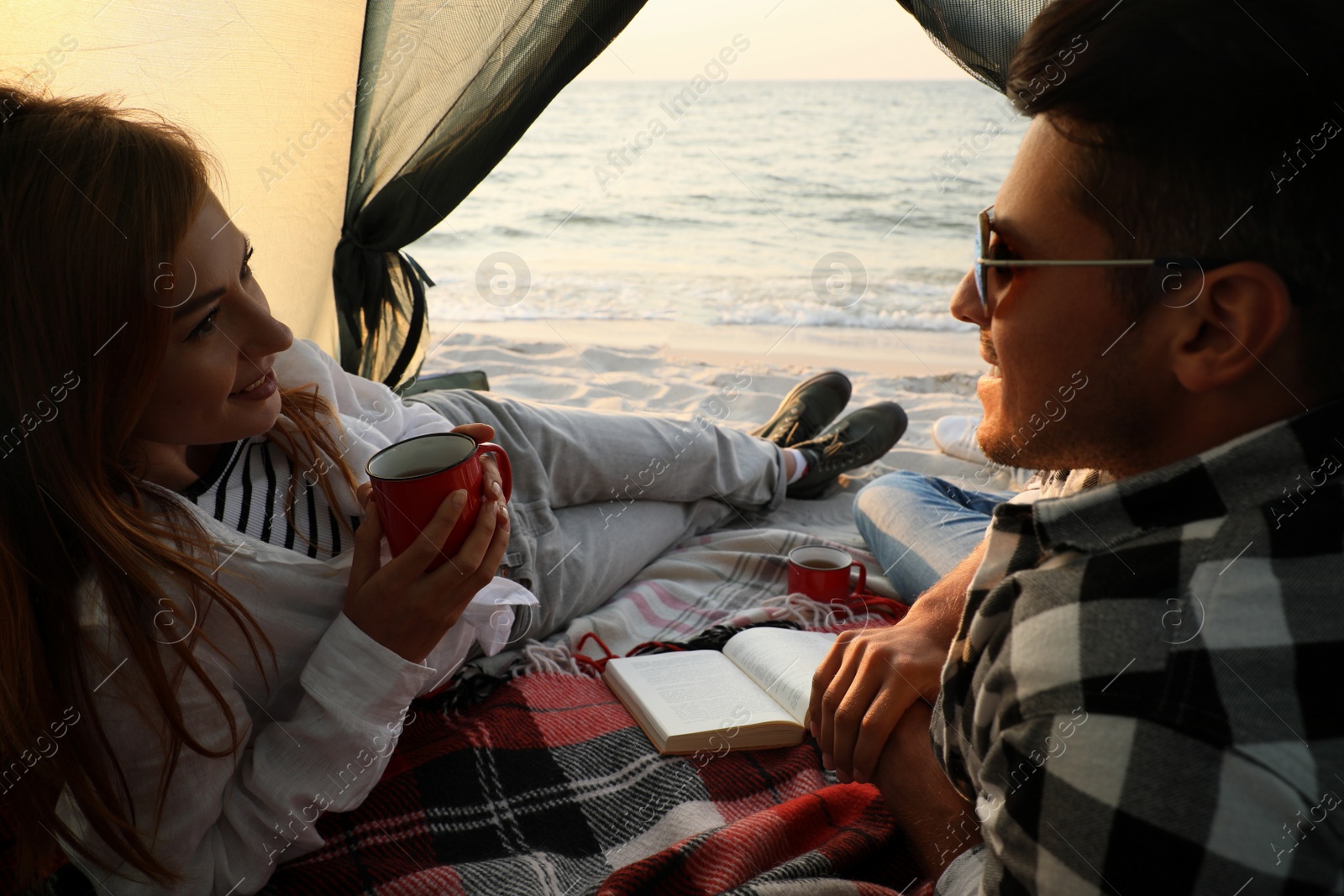 Photo of Couple resting in camping tent near sea