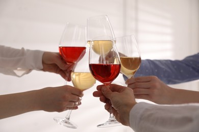 Photo of People clinking glasses of wine on white background, closeup