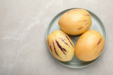 Fresh ripe pepino melons on light table, top view. Space for text