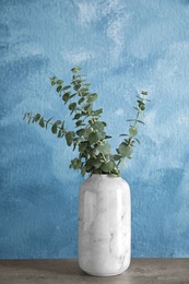 Bunch of eucalyptus branches with fresh leaves in vase on table