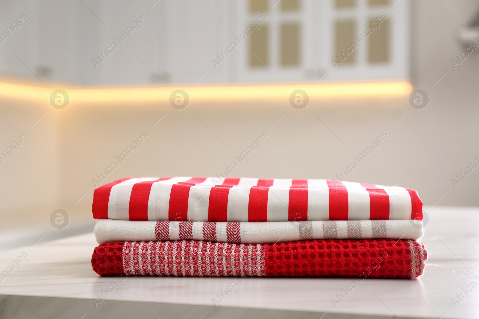 Photo of Stack of soft kitchen towels on white table indoors