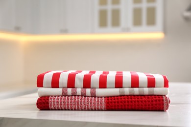 Stack of soft kitchen towels on white table indoors