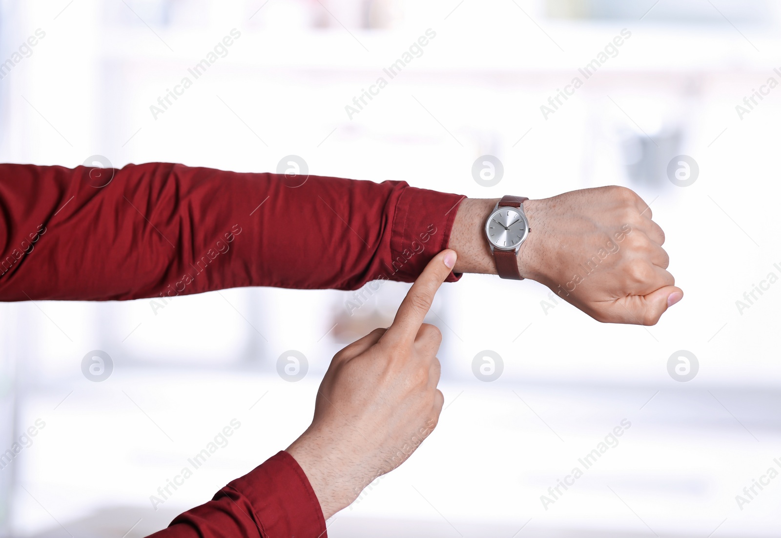 Photo of Young man with wristwatch on blurred background, Time concept