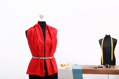 Photo of Mannequin with red cloth in tailor studio