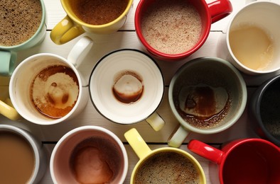 Photo of Many different cups with aromatic coffee and dirty ones on white wooden table, flat lay