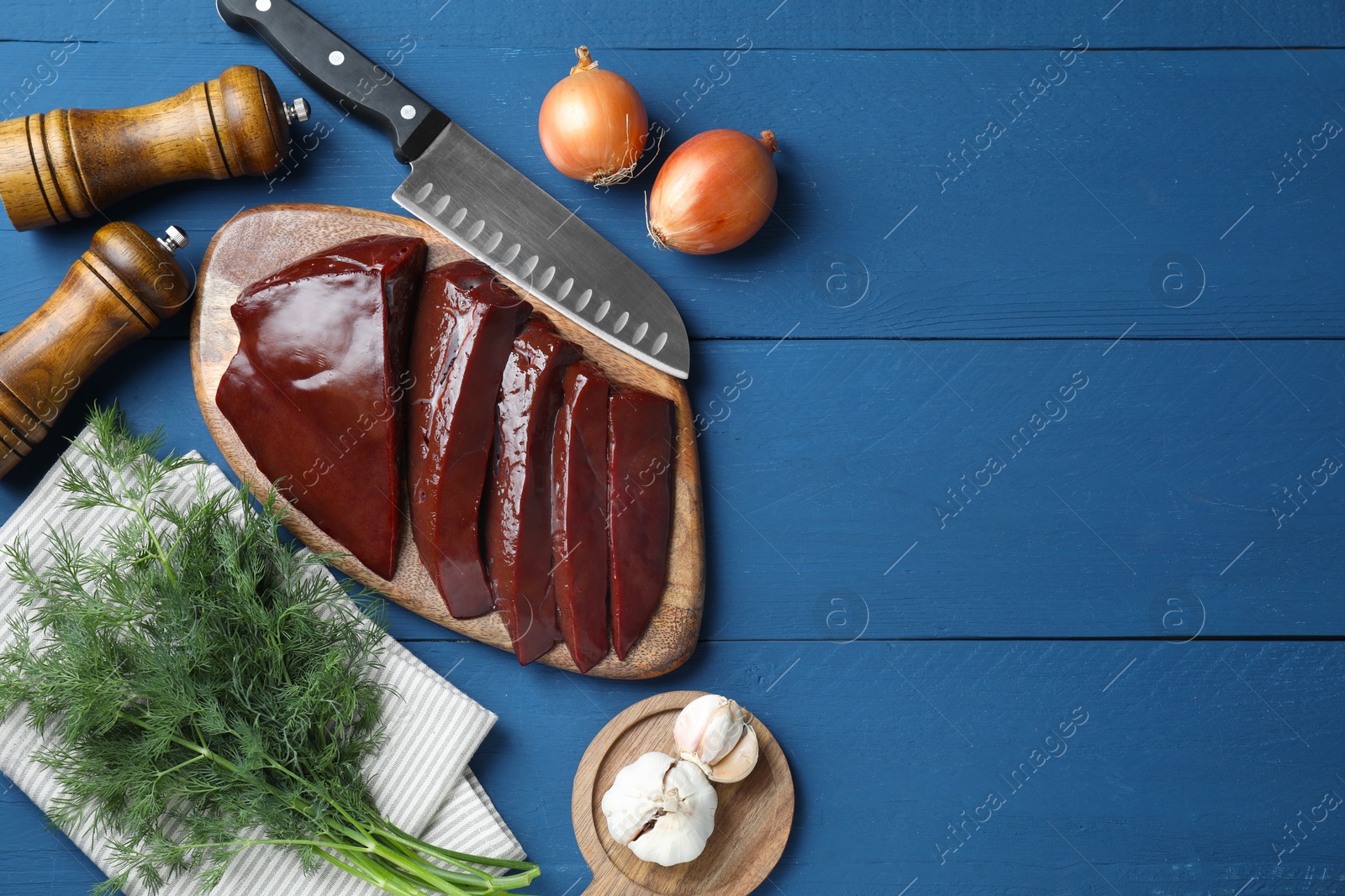 Photo of Flat lay composition with cut raw beef liver on blue wooden table. Space for text