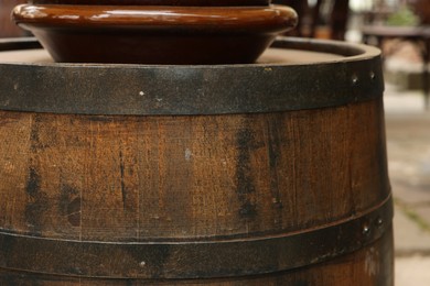 Photo of Traditional wooden barrel outdoors, closeup. Wine making