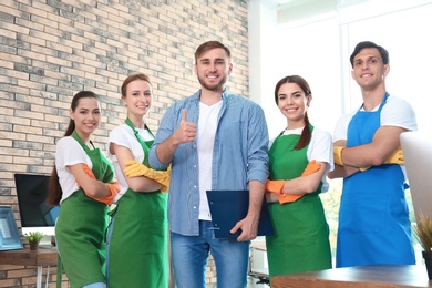 Photo of Team of professional janitors in uniform indoors