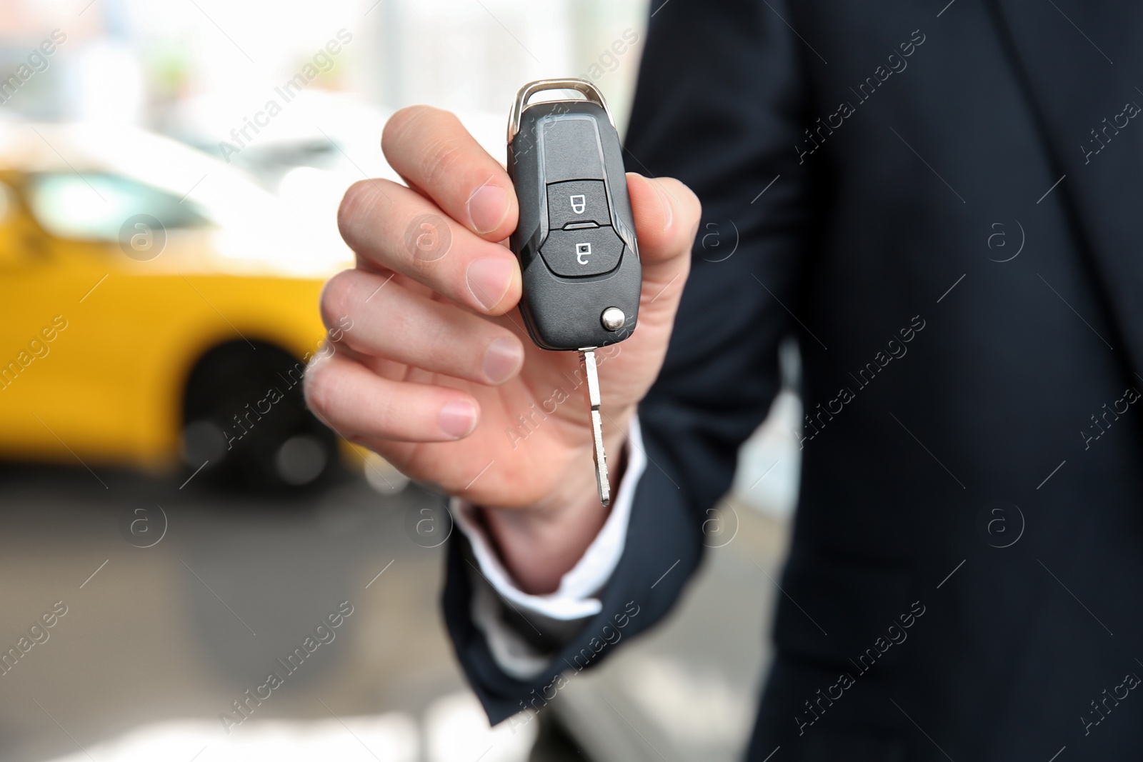 Photo of Businessman with key in dealership. Buying new car