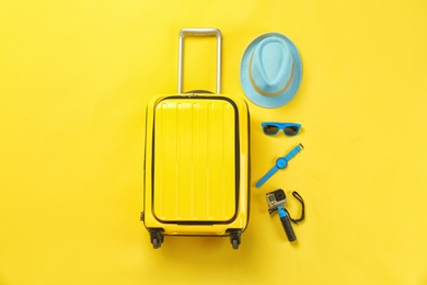 Photo of Flat lay composition with suitcase and accessories on color background