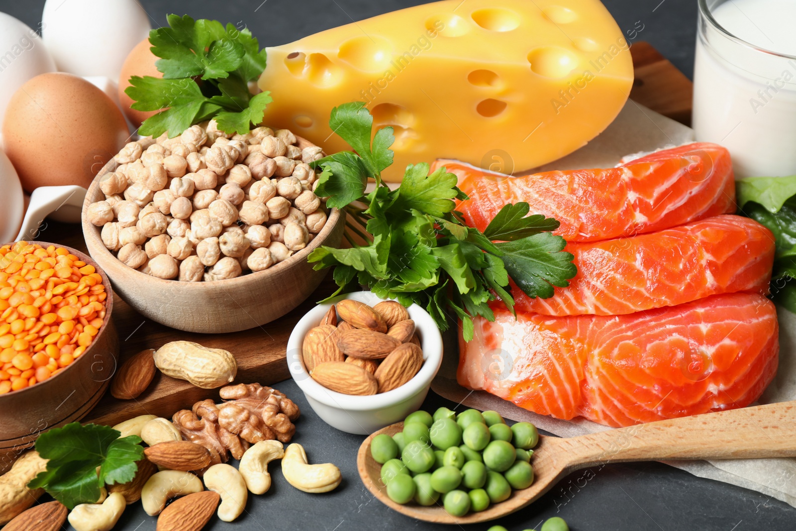 Photo of Different products rich in protein on black table, closeup