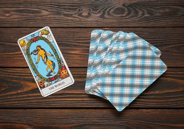 Photo of The World and other tarot cards on wooden table, flat lay