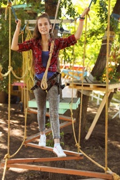 Photo of Teenage girl climbing in adventure park. Summer camp