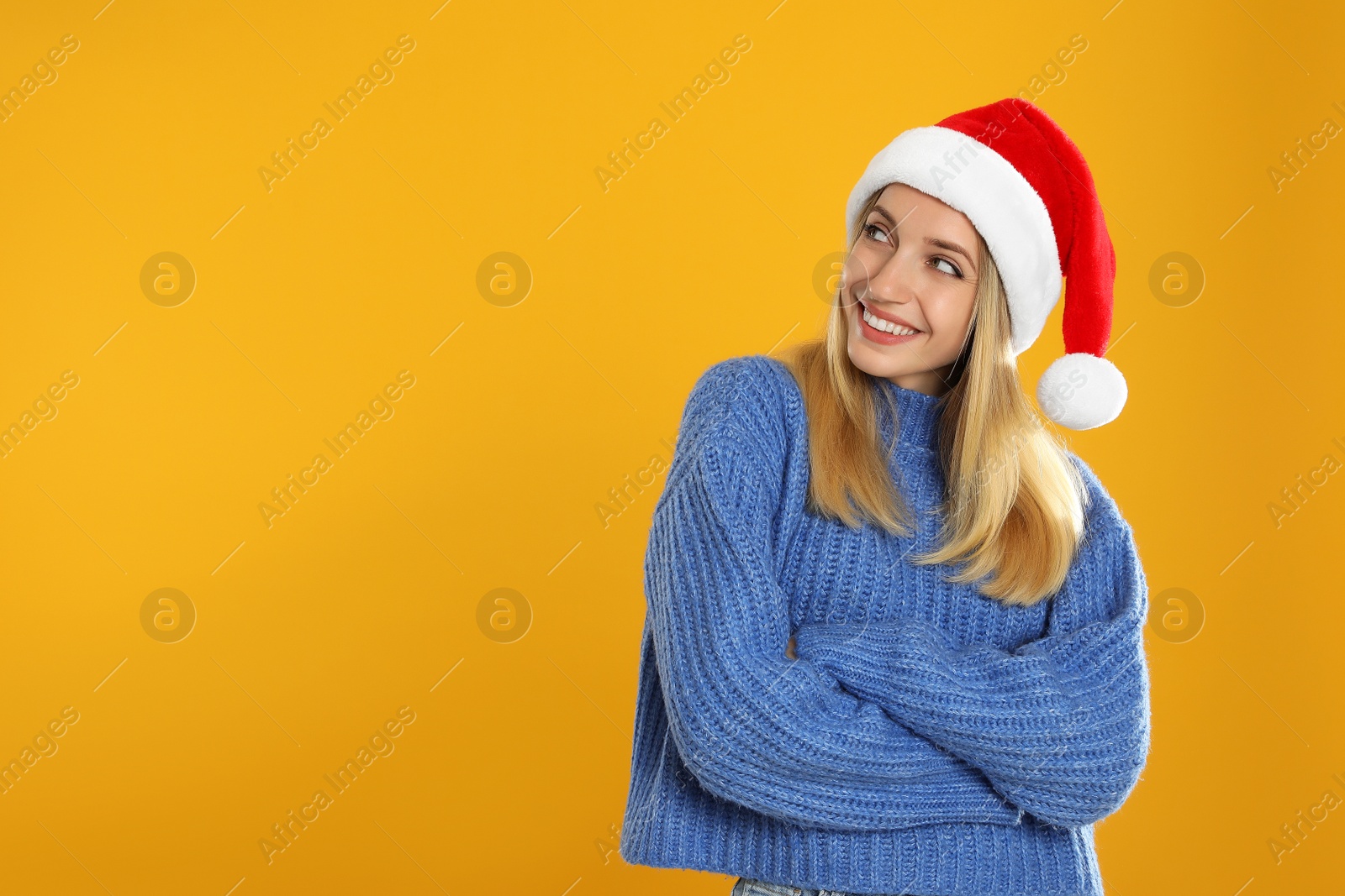 Photo of Happy woman in Santa hat on yellow background, space for text. Christmas countdown