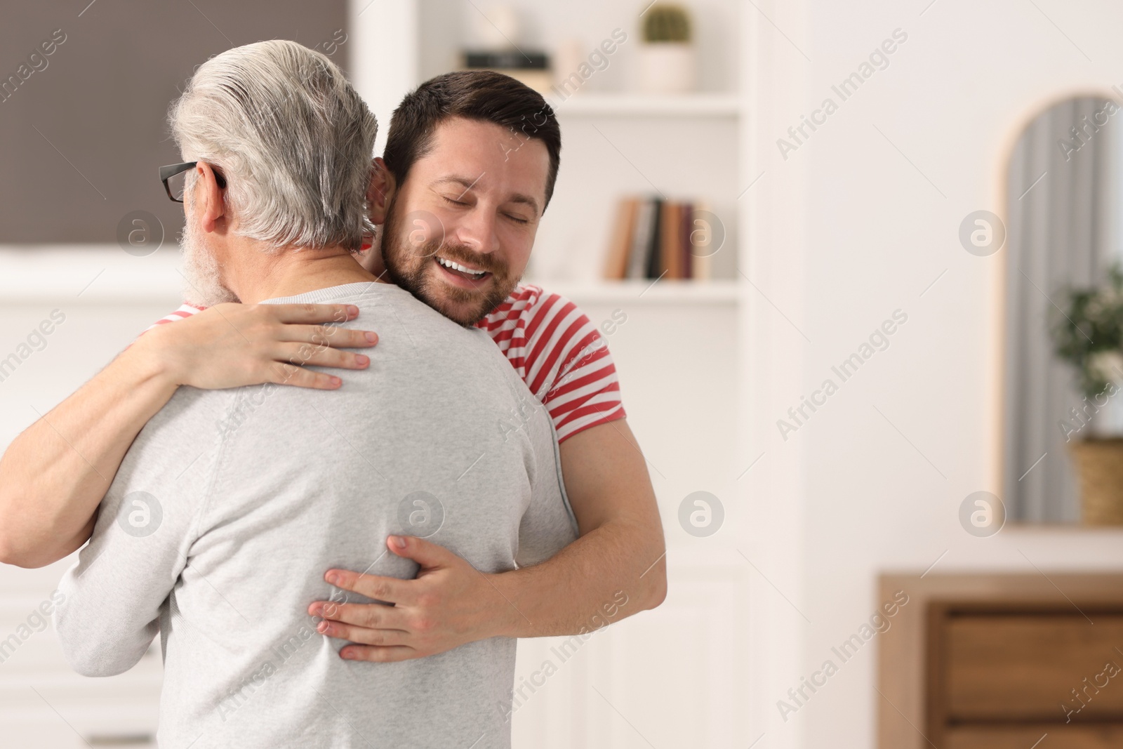 Photo of Happy son and his dad at home, space for text