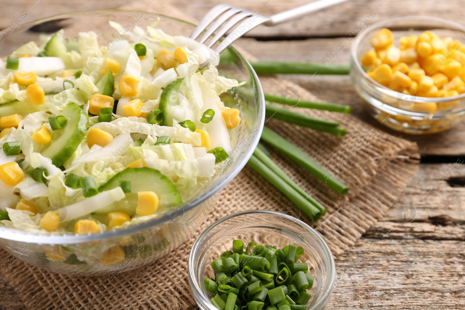 Photo of Tasty salad with Chinese cabbage served on wooden table, closeup