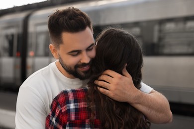 Long-distance relationship. Couple hugging on platform of railway station