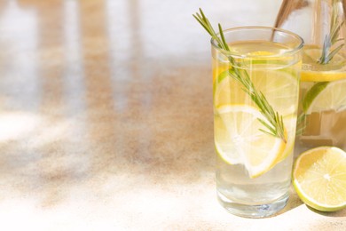 Photo of Tasty refreshing lemonade and ingredients on light table, space for text. Summer drink