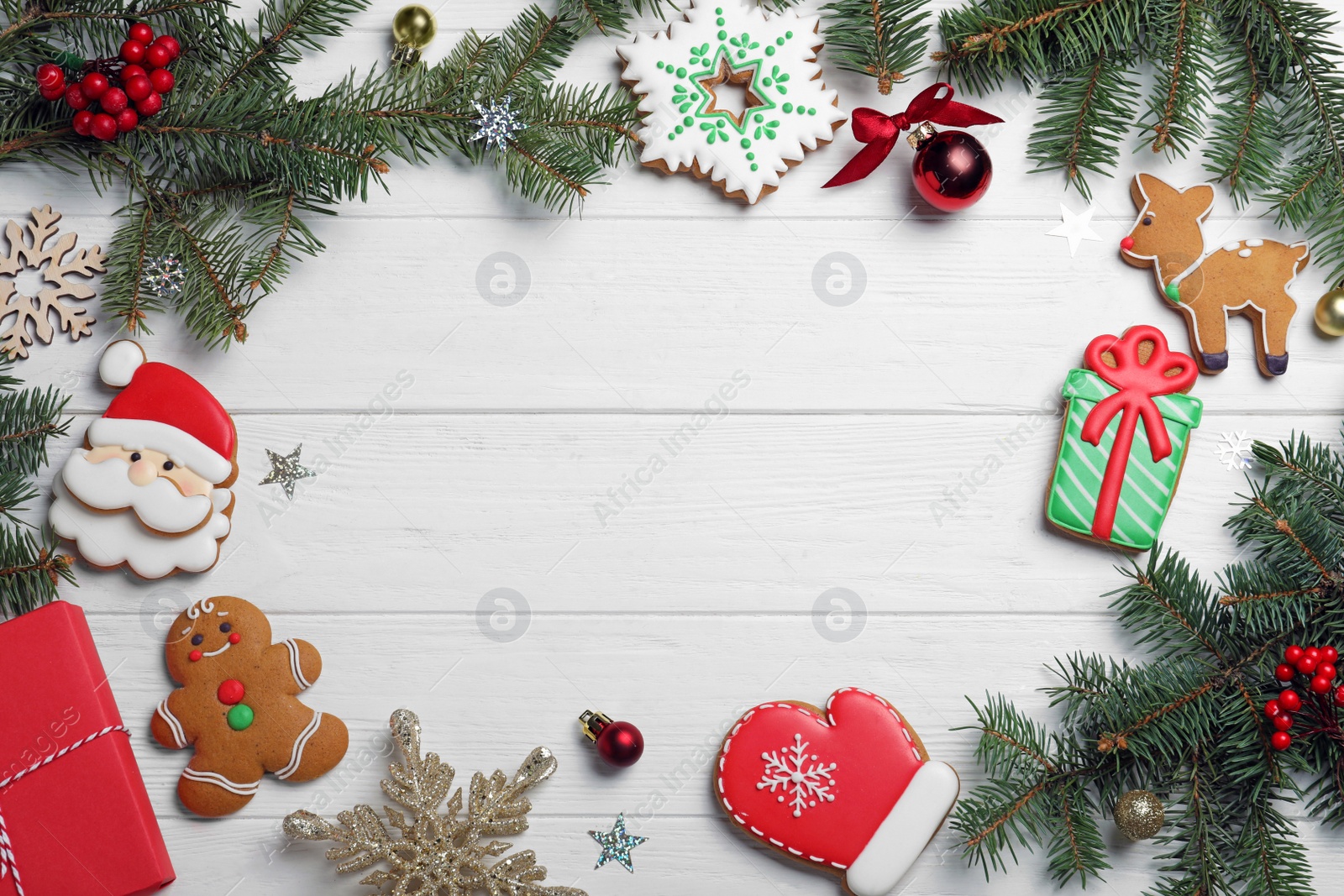 Photo of Frame of tasty homemade Christmas cookies and fir tree branches on white wooden table, flat lay. Space for text