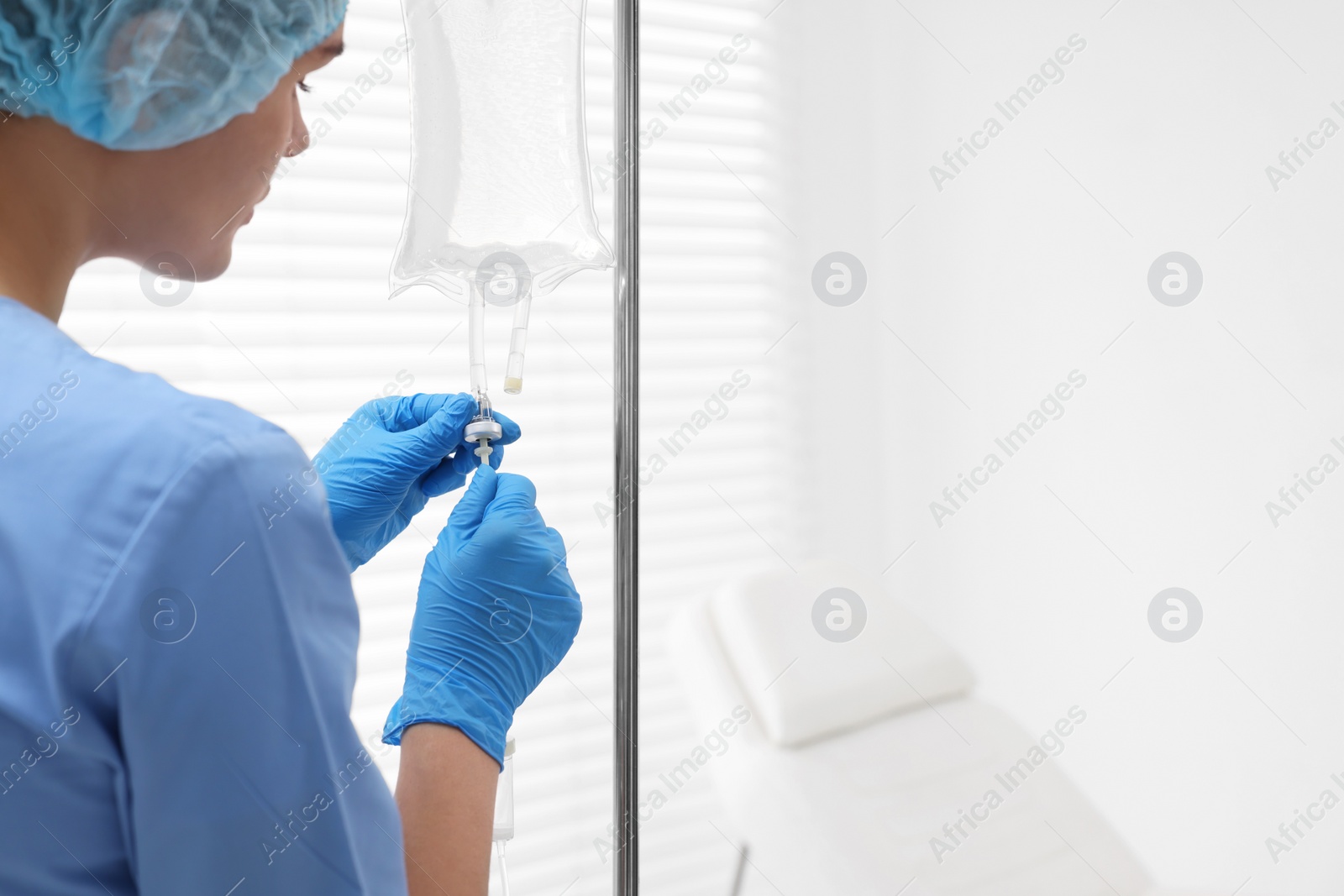 Photo of Nurse setting up IV drip in hospital, closeup. Space for text