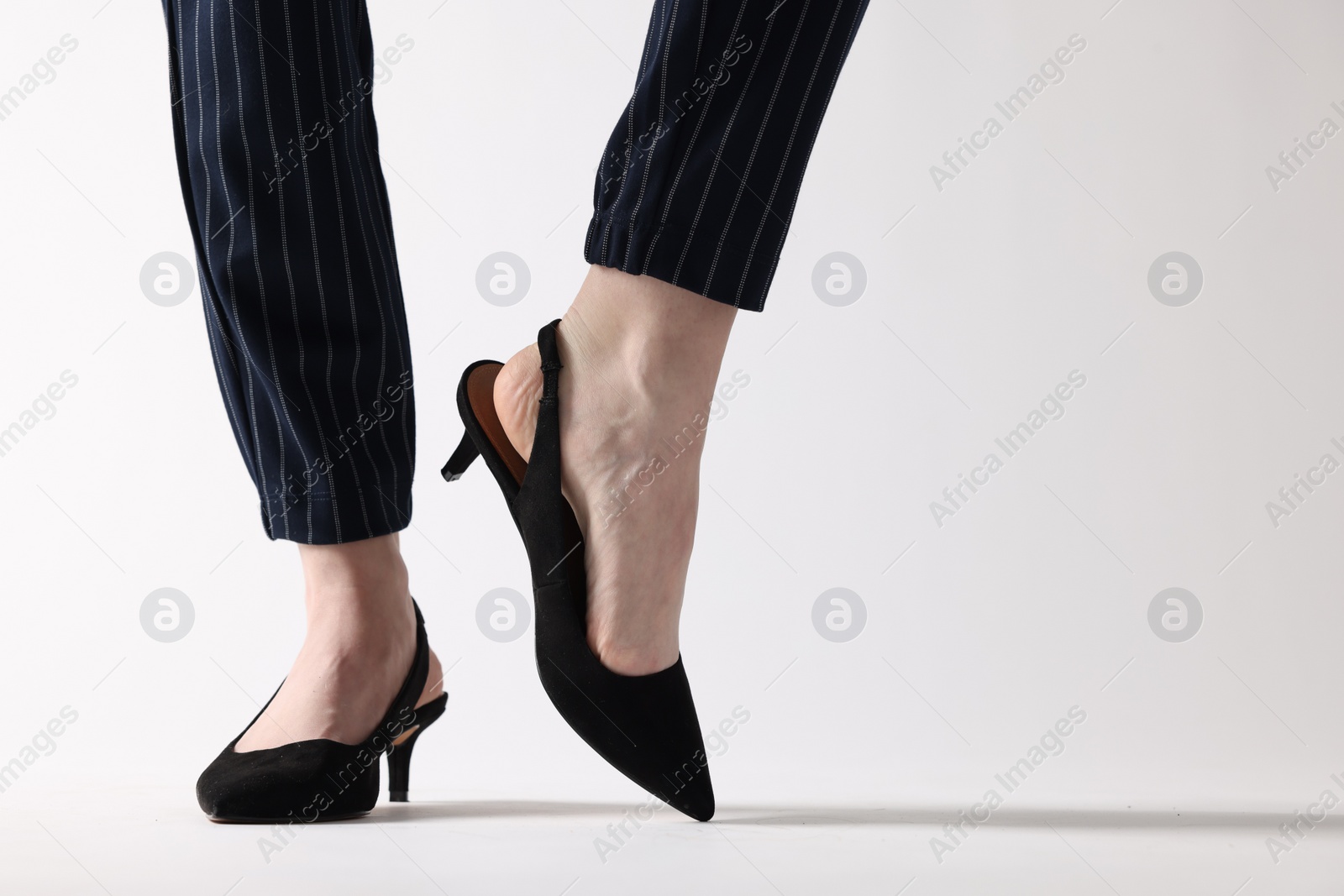 Photo of Businesswoman in black shoes on white background, closeup