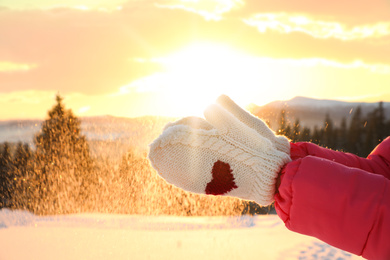 Photo of Young woman having fun outdoors on snowy winter day, closeup