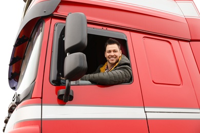 Photo of Portrait of happy driver in cab of modern truck