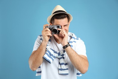 Photo of Male tourist taking picture on turquoise background