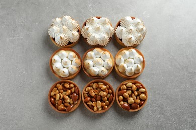 Many different tartlets on light grey table, flat lay. Tasty dessert