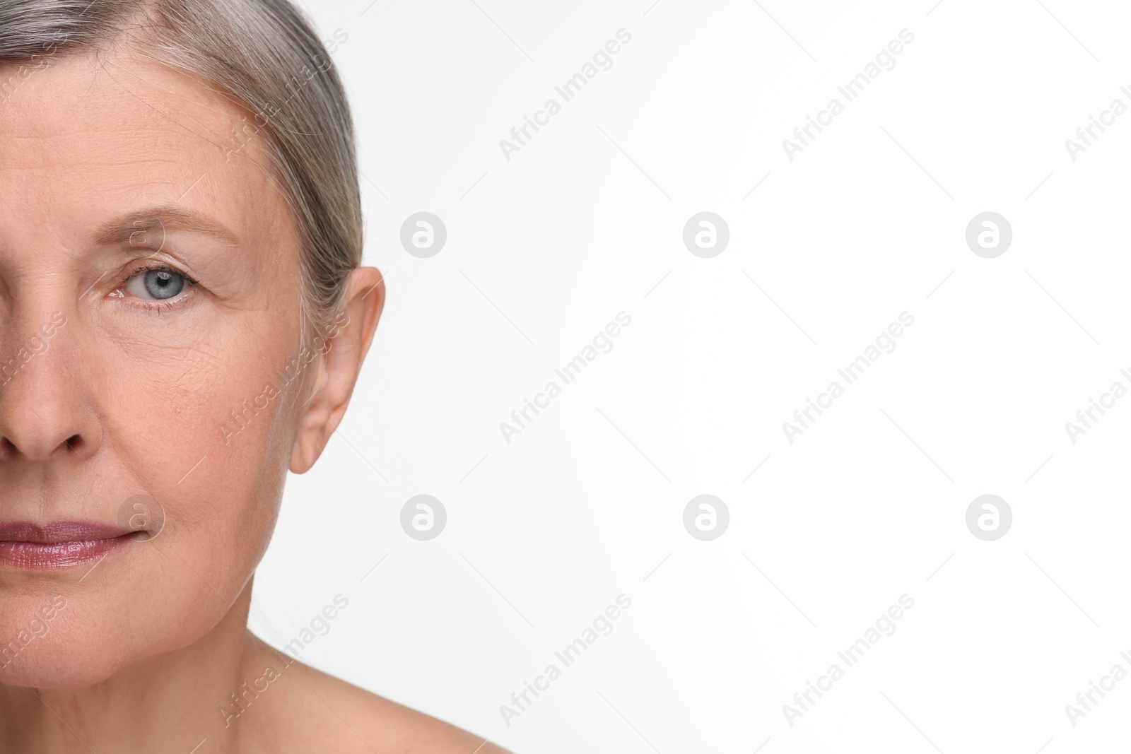 Photo of Senior woman with aging skin on white background, closeup. Rejuvenation treatment