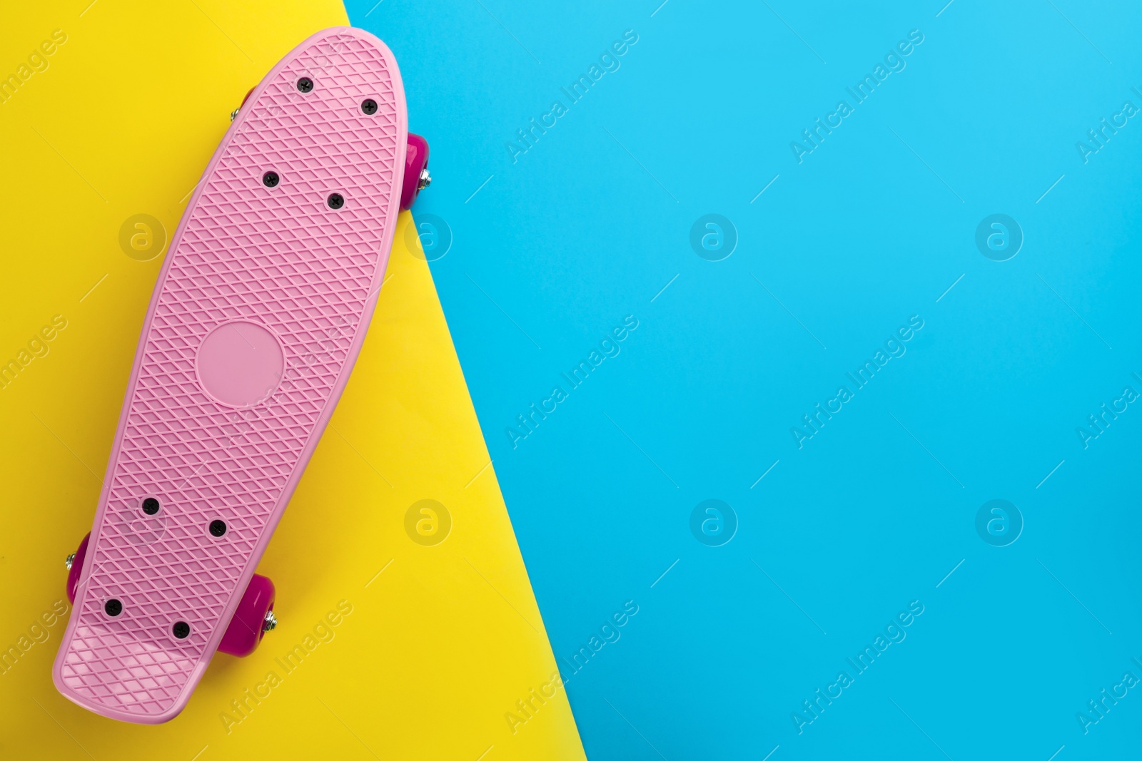 Photo of Pink skateboard on color background, top view. Space for text