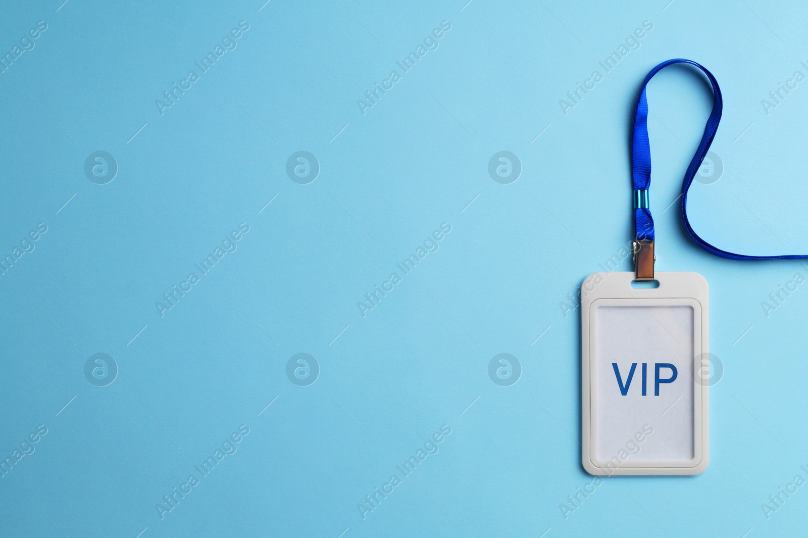 Photo of Plastic vip badge on light blue background, top view. Space for text