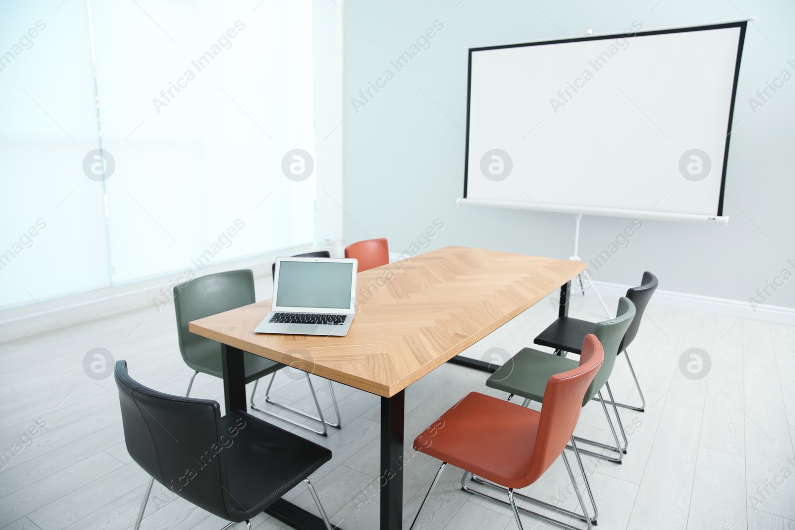 Photo of Conference room interior with wooden table and video projection screen