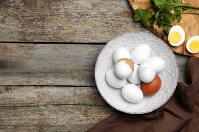 Photo of Flat lay composition with boiled eggs on wooden table. Space for text