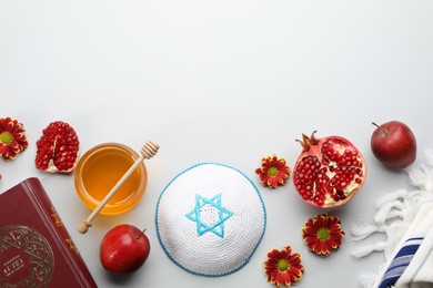 Photo of Flat lay composition with Rosh Hashanah holiday attributes on white background. Torah book with text in hebrew