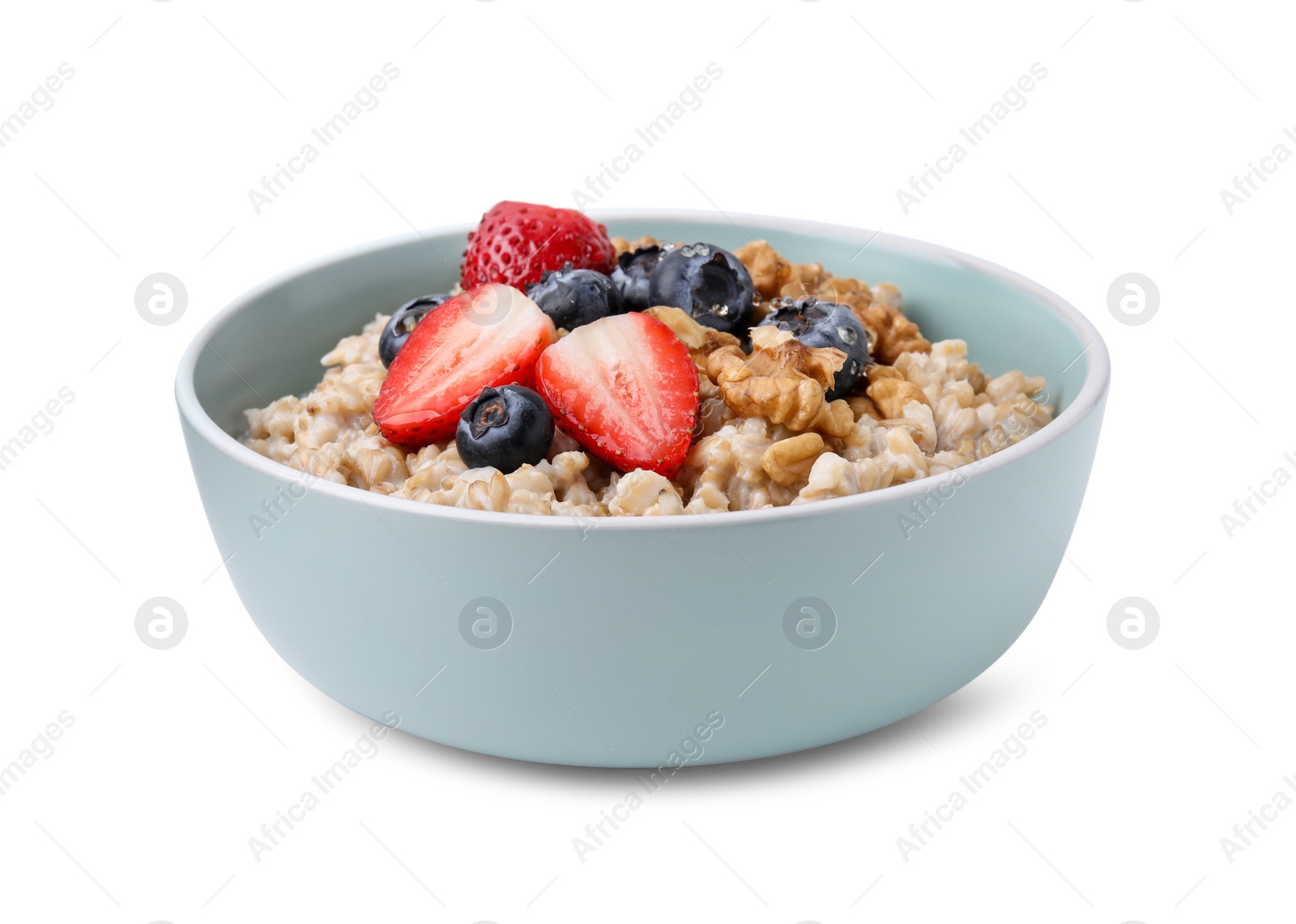 Photo of Tasty oatmeal with strawberries, blueberries and walnuts in bowl isolated on white