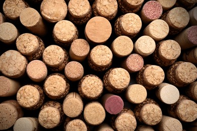 Photo of Many corks of wine bottles as background, top view