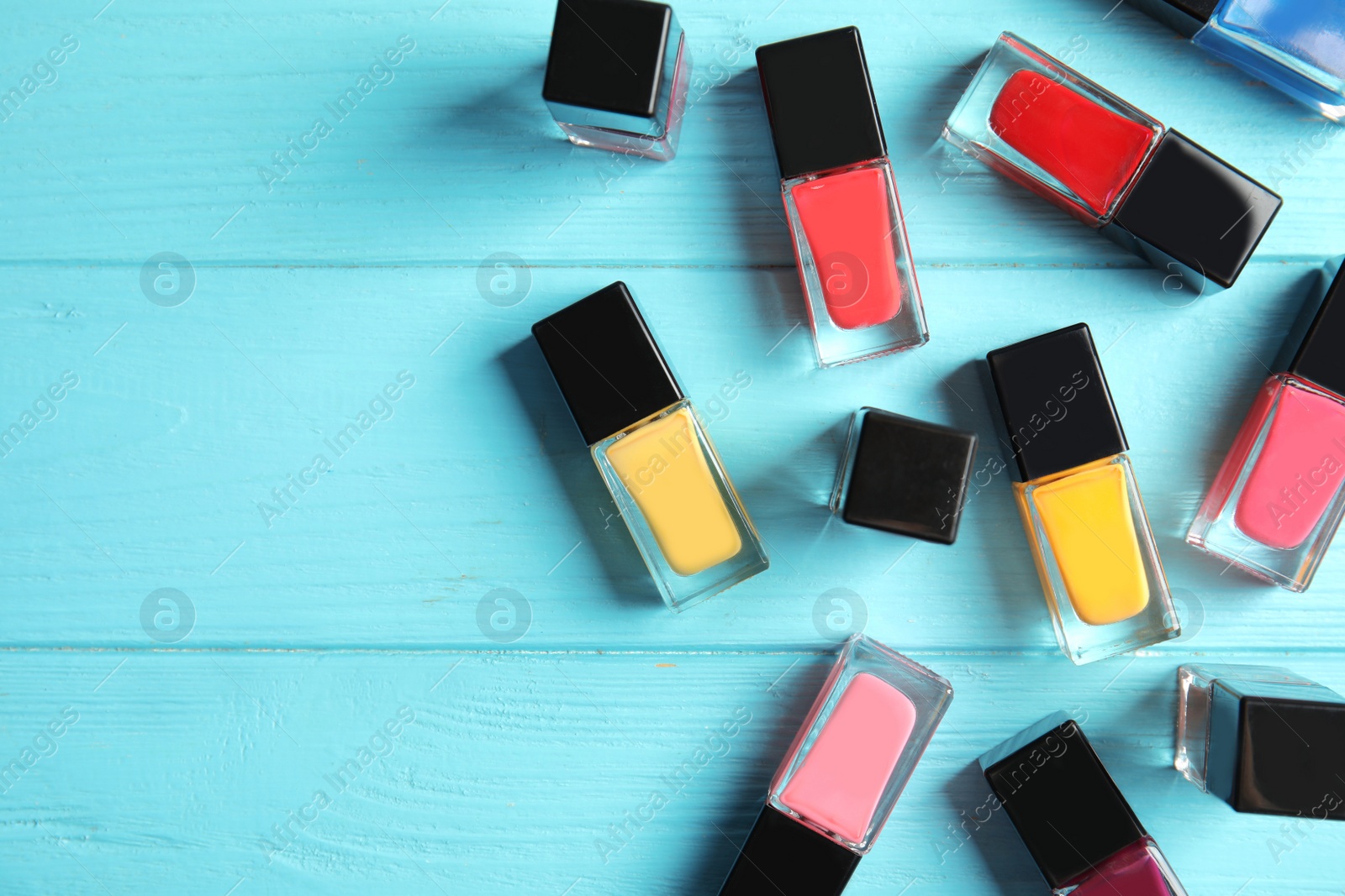 Photo of Bottles of nail polish on color background, top view with space for text