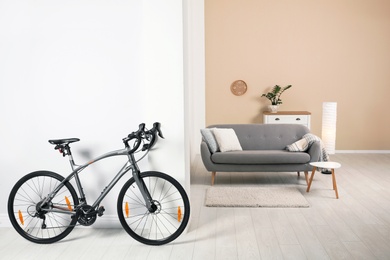 Photo of Modern apartment interior with bicycle near wall. Space for text