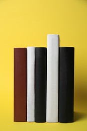 Collection of hardcover books on yellow background