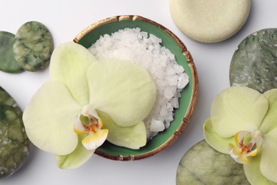 Flat lay composition with stones, spa products and beautiful flowers on white table