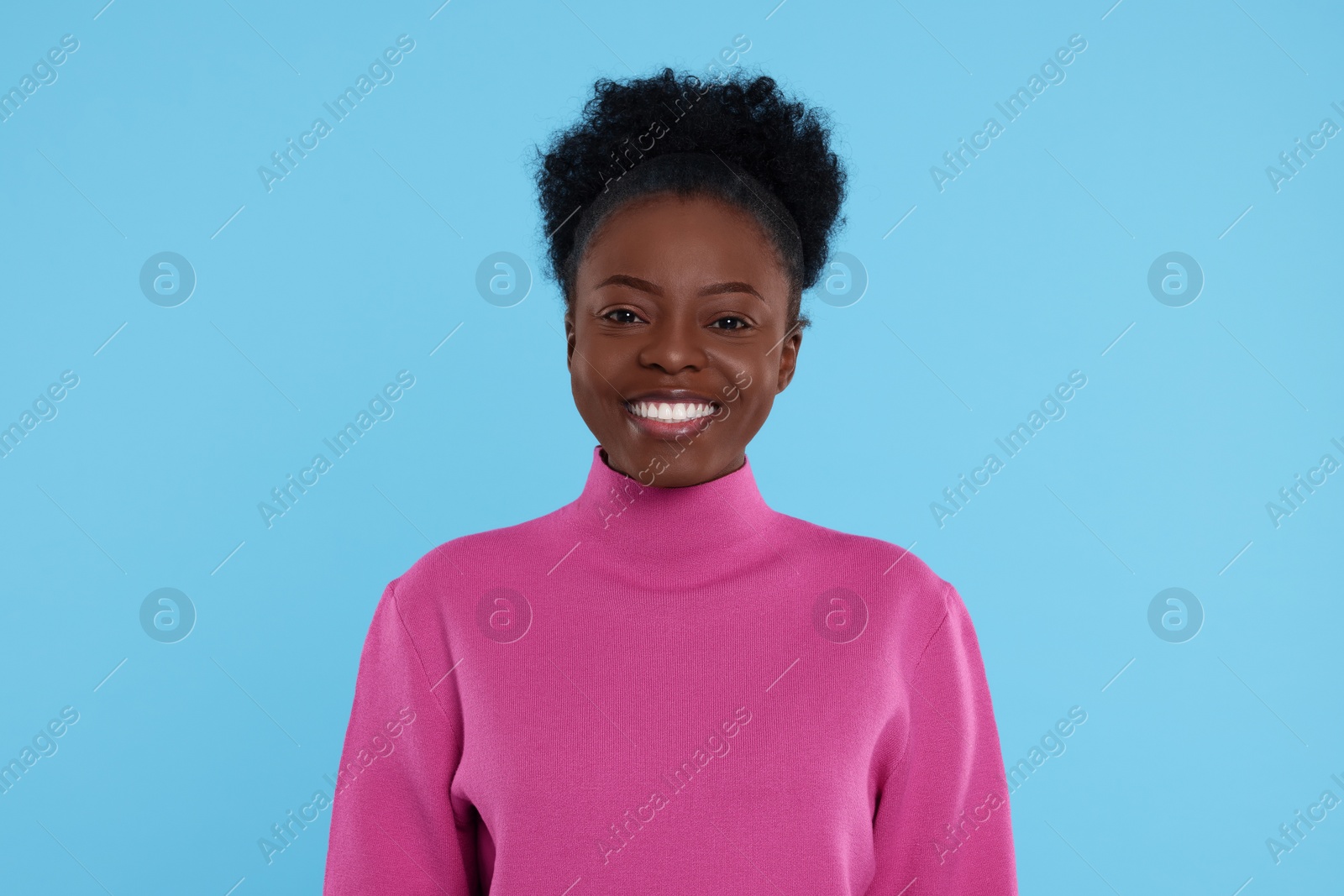 Photo of Portrait of happy young woman on light blue background